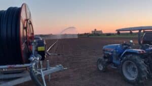 Getto d'acqua ad ampio raggio generato da un irrigatore professionale Orma Srl attivo in pieno campo durante le operazioni di irrigazione stagionale